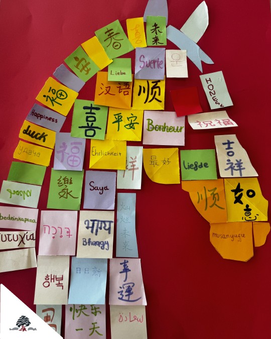 Mural con forma de caballo realizado con papeles de colores y palabras en diferentes idiomas por alumnado de Primaria.