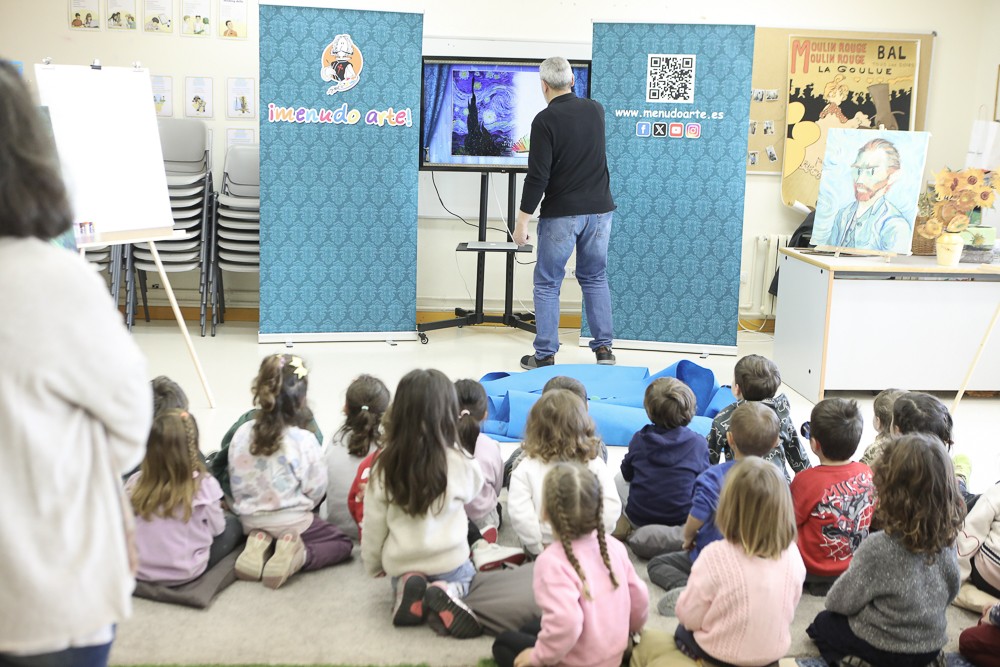 Alumnado del Colegio Juan de Lanuza observa una presentación sobre arte durante un taller de Menudo Arte.