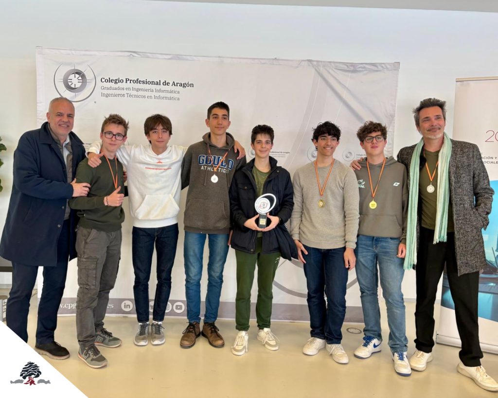 Grupo de participantes en la Olimpiada Informática Aragonesa 2026 con medallas y un trofeo.