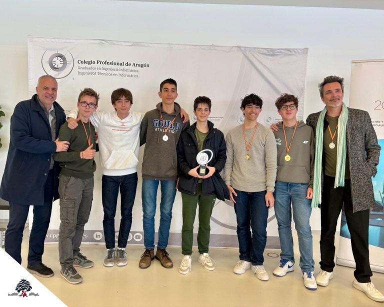 Grupo de participantes en la Olimpiada Informática Aragonesa 2026 con medallas y un trofeo.