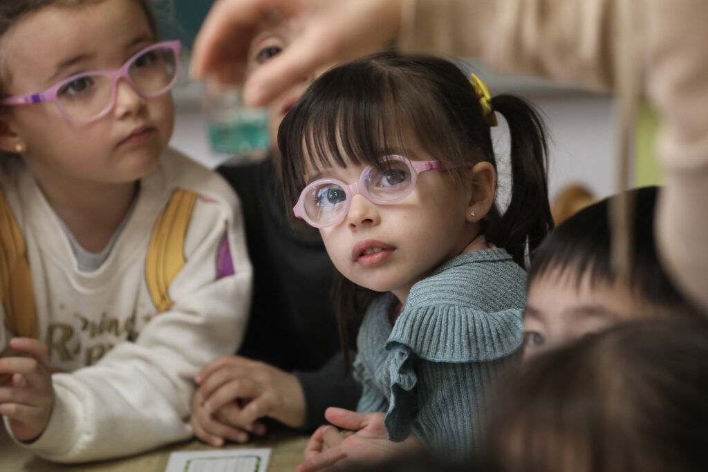Alumnas de Infantil con gafas, atentas durante una actividad en el aula