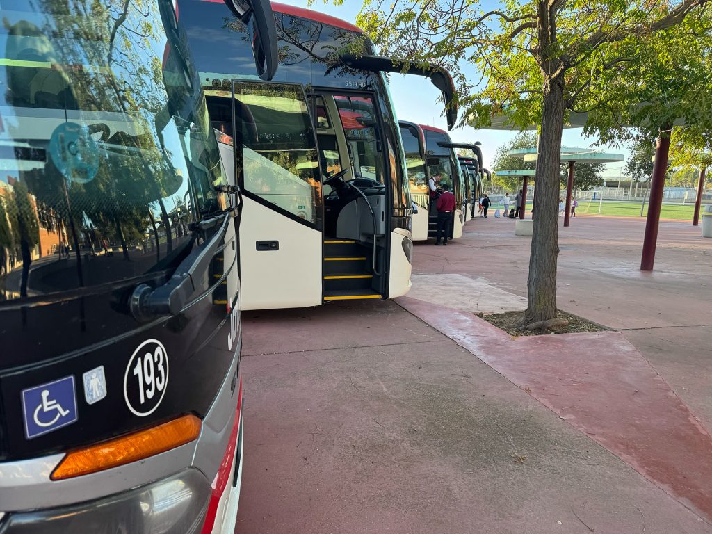 Autobuses de transporte escolar estacionados junto al Colegio Juan de Lanuza en Zaragoza.