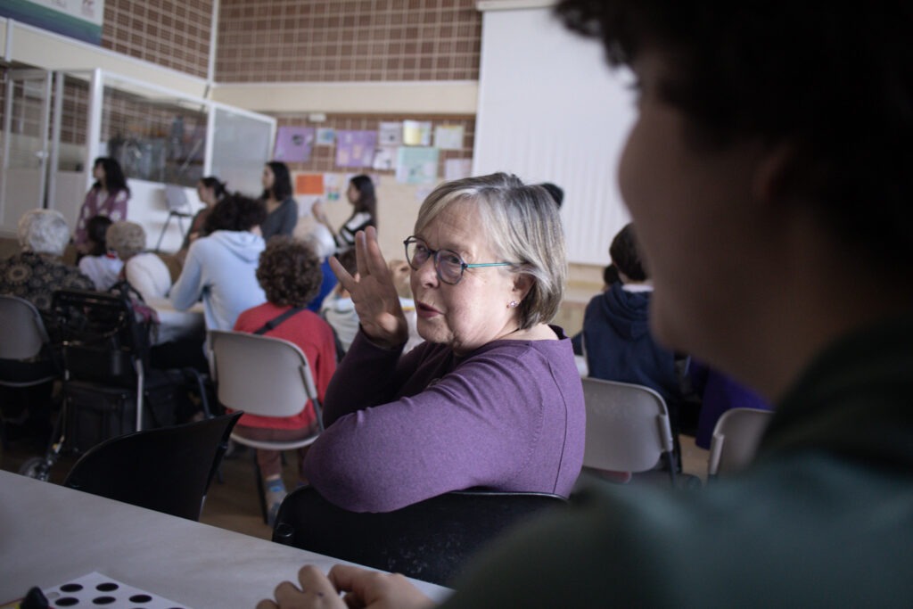 Persona mayor conversando con un estudiante durante una actividad de voluntariado del programa Soy Más.