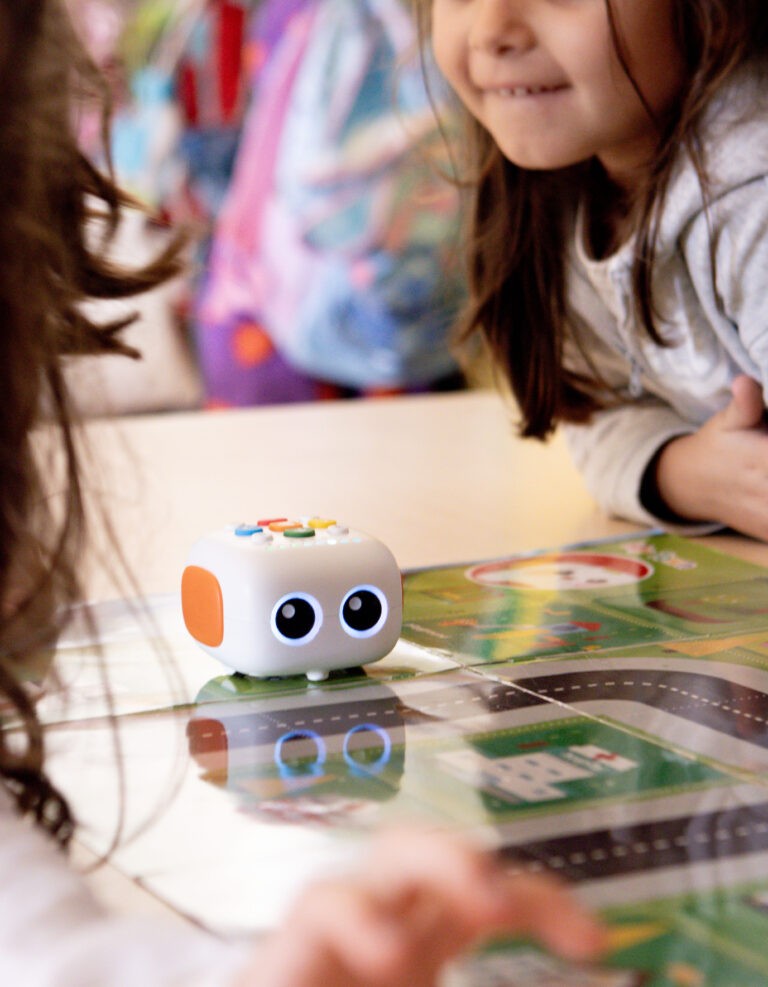 Alumnado trabajando con un robot educativo sobre un tablero de programación.