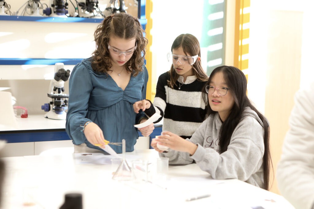 Tres alumnas realizan una actividad práctica de ciencias con materiales de laboratorio en el Colegio Juan de Lanuza.